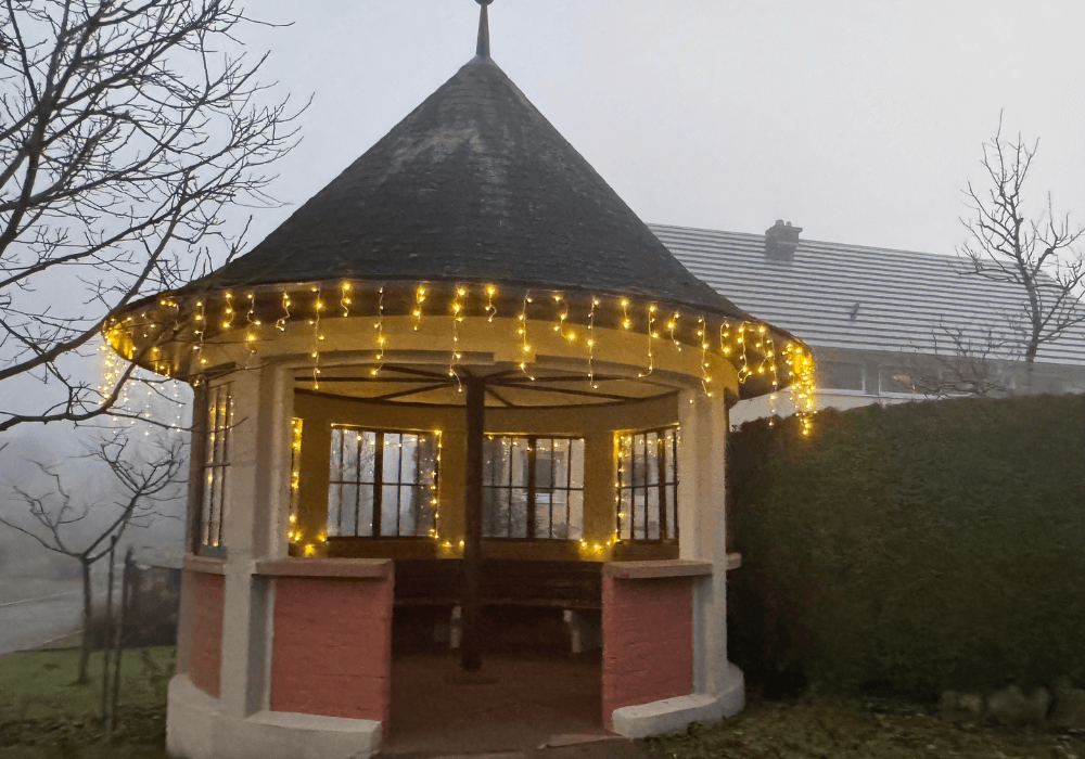 Bushaltehaus von außen mit Lichterketten
